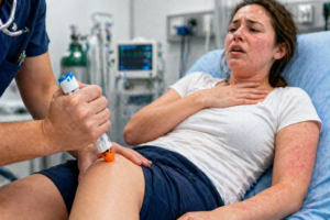 tratament anafilaxie administrare epipen injectie adrenalina in coapsa pacient cu reactie alergica severa dificultate respiratorie imagine medicala realista stil clinic curat